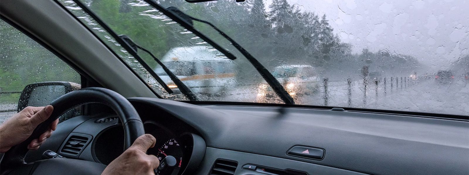 A man is driving in raining.