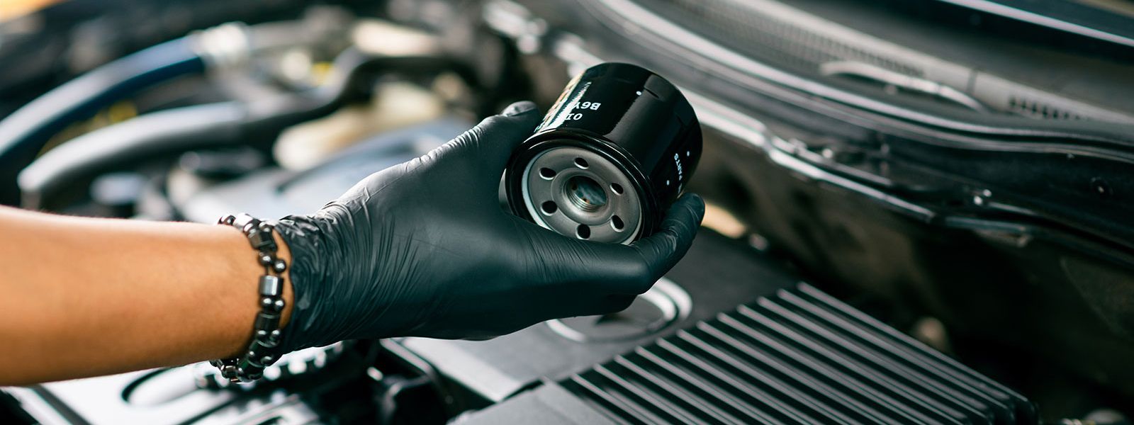 A man replaces an oil filter housing